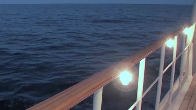 From the ship's deck, a tranquil view of the Arctic Ocean unfolds. Gentle waves undulate beneath the twilight sky.