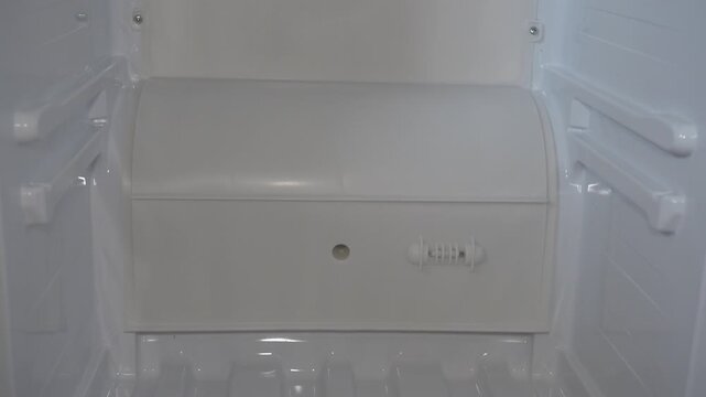 Inside of a completely empty white refrigerator close up, Concept of empty refrigerator or shortage of food at home
