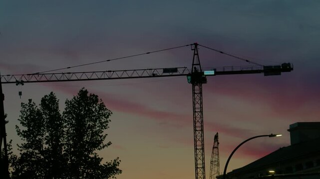 Construction crane silhouette against sunset sky with copy space