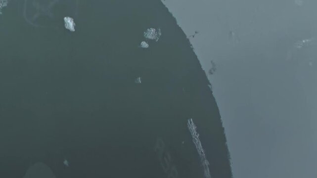 Observe a ship's resolute voyage through the frigid Arctic Ocean. Giant ice sheets fracture and disperse, as the vessel powerfully forges a path across the immense frozen landscape.
