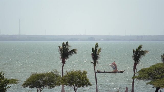 Humble artisanal fisherman sailing a makeshift boat with makeshift cloth sails on Lake Maracaibo, Venezuela