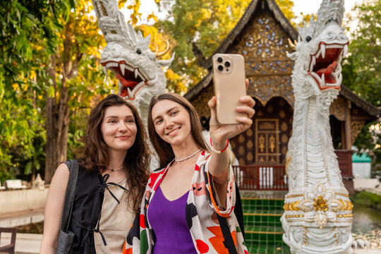 Two Friends Take a Selfie at a Temple in Thailand During the Daytime