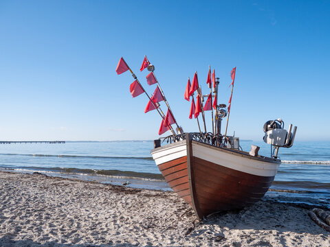 Fishing Vessel with Red Flags on Baltic Sea Shore