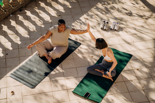 Two women practice yoga on the terrace