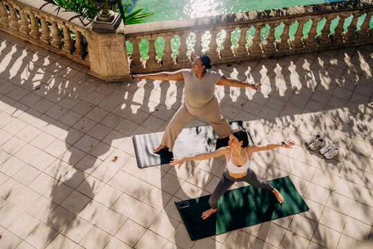 Two women practice yoga on the terrace