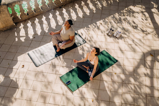 Two women practice yoga on the terrace