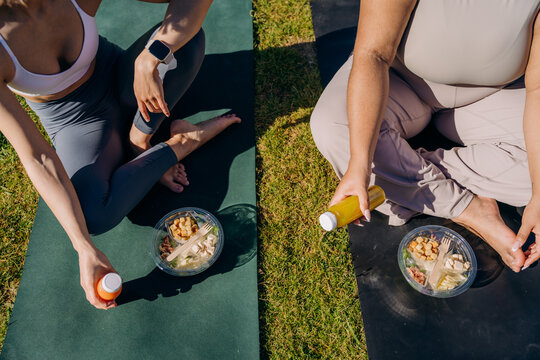 Two women eat lunch after a workout