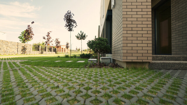 Modern residential building with ecological grass pavers leading to the entrance, contemporary garden design