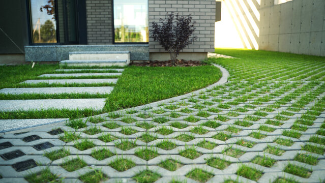 Exterior view of a contemporary house featuring a modern garden path with grass pavers and stone steps