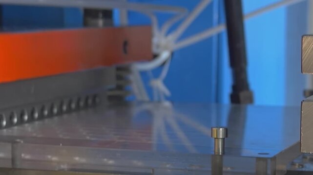 Watch as a powerful industrial machine methodically presses metal sheet parts, designed for industrial air conditioners, capturing every detail in smooth, slow motion.