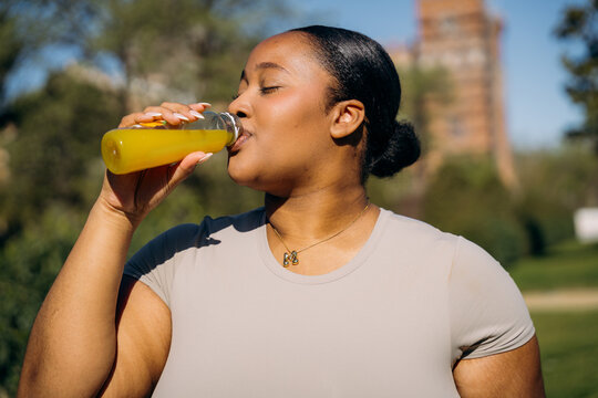 A woman drinking juice from a bottle