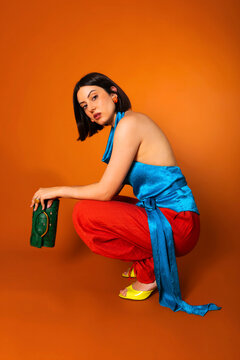Woman crouching with stylish colorful outfit