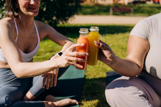 Two women with juice bottles in their hands