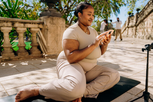 A woman using a mobile phone sitting outdoors