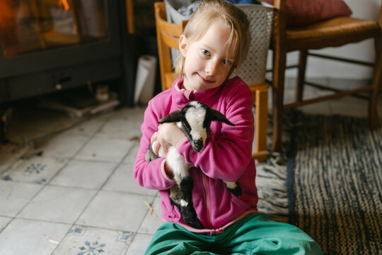 little girl with baby goat in family rom 