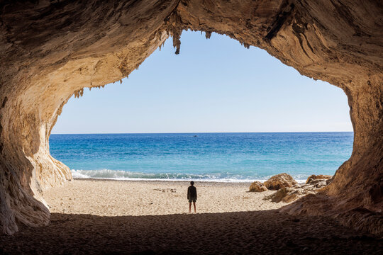 A boy stands in the cave of Cala Luna Sardinia