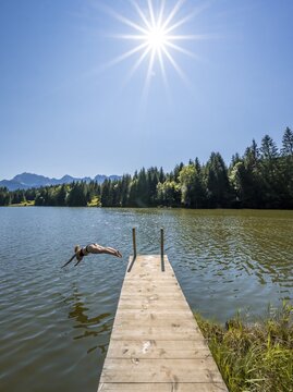 Young woman taking a header into a lake, Geroldsee, Mittenwald, Karwendel, Bavaria, Germany