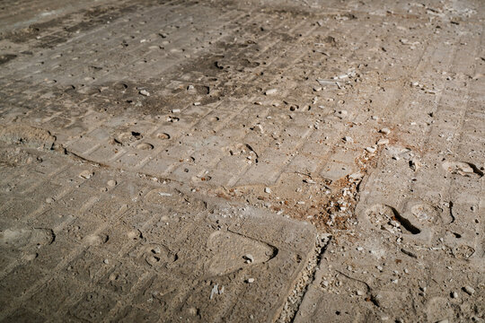 Industrial Concrete Floor Showing a Rough Grid Pattern Texture Left Behind by Popped Ceramic Tiles