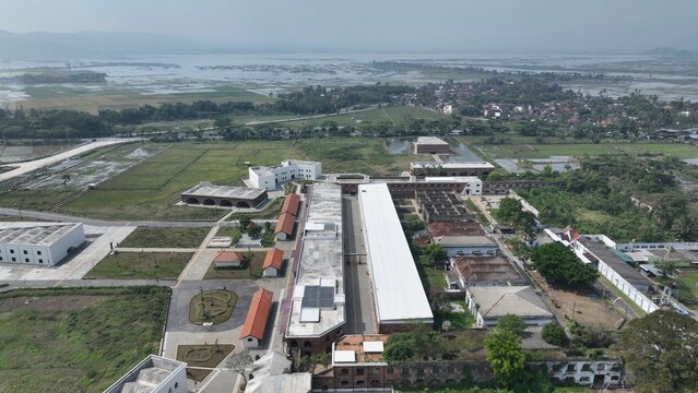 Aerial view of the historic Fort Willem I featuring long colonial-era buildings, white roofs, and surrounding green fields in Ambarawa, Central Java, Indonesia.