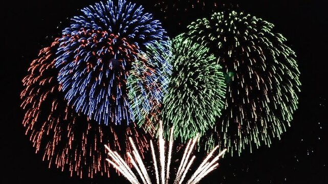 Vibrant fireworks exploding in the night sky with colorful bursts of light and energy