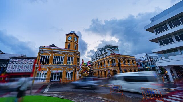 Time lapse Long exposure photograph capturing motion blur traffic beneath the iconic Phuket City clock tower with storm clouds gathering over the historic Sino Portuguese district.
