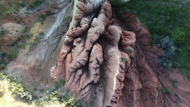 Birds eye view drone shot looking down at an otherworldly geological ridge featuring heavily texturized mud wrinkles and multi-colored clay folds in Central Asia, Kazakhstan.
