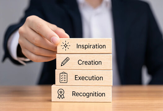 Businessman placing wooden block with inspiration on top of creation execution recognition blocks on desk transparent background