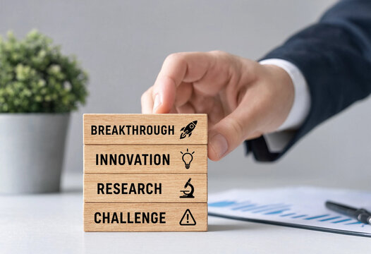 Businessmans hand stacking wooden blocks with words breakthrough innovation research challenge and icons symbolizing growth strategy and discovery for business success