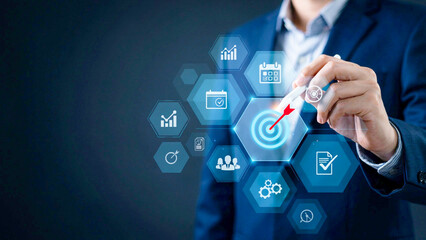 Obraz premium A man in a blue suit holds a pen near a futuristic interface with various icons.