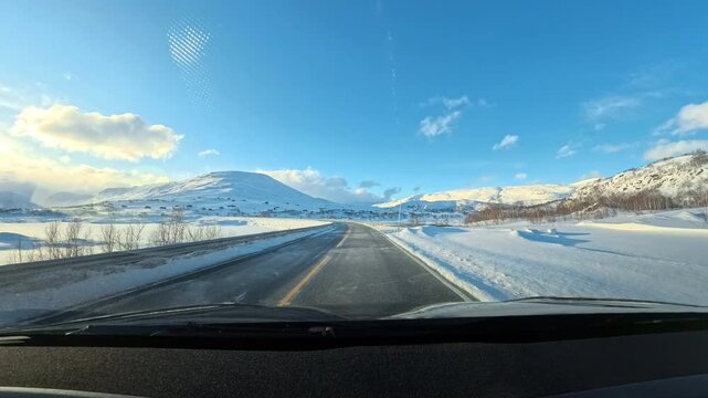 Beautiful winter landscape from a moving car on a snow-covered highway in Norway