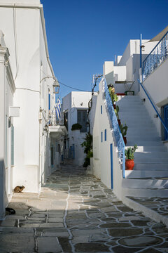 Traditional white Greek residential buildings and houses with blue doors and windows in the village of Lefkes on Paros island in Greece on a sunny day.