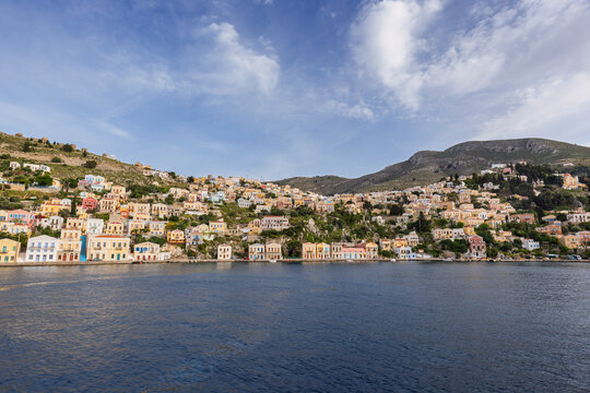 Colorful buildings on a hillside in the idyllic town of Symi by the Aegean Sea on Symi (Simi, Syme) island in Greece on a sunny day.
