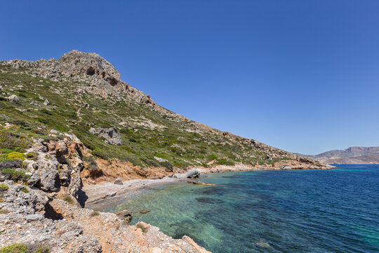 Mountainous, rugged and lush landscape, coastline and the Aegean Sea on Telendos island in Greece on a sunny day.
