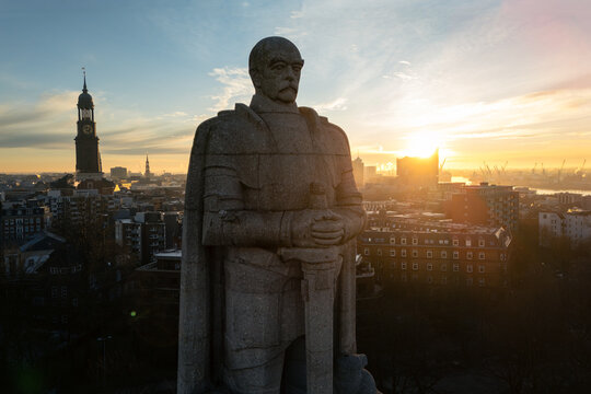 Aerial view of the Bismarck Monument with the city skyline of Hamburg, including St. Michael's Church and the Elbphilharmonie during a golden sunset in Hamburg, Hamburg, Germany.