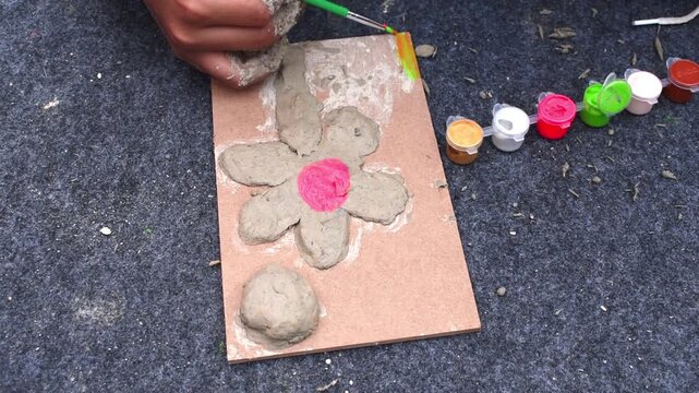 kids painting on board having clay flower on mdf board