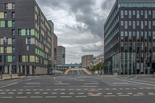 Modern city street intersection with empty urban road under overcast sky creating somber atmosphere