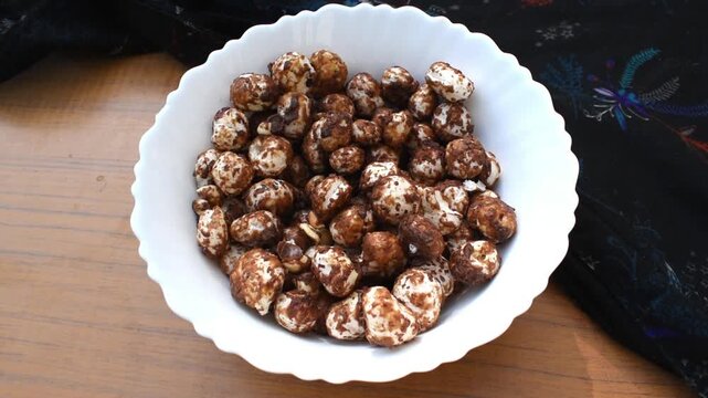 Homemade jaggery and cocoa-coated makhana served in a white bowl, offering a crunchy and convenient snack for travel, road trips, office breaks, and lunch boxes