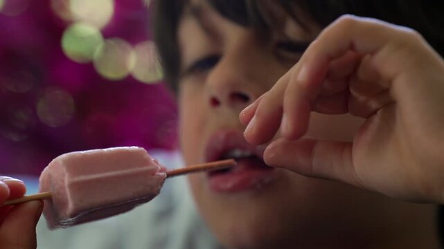 Young boy savoring frozen strawberry treat outdoors, celebrating childhood joy, summer lifestyle and family recreation