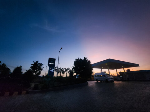 Theni, Tamil Nadu, India &ndash; June 27, 2026: Twilight view of a Nayara Energy petrol station with vehicles, illuminated forecourt, and colorful dusk sky in Theni district, Tamil Nadu