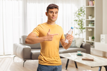 Fototapeta premium Young man pointing at a bottle