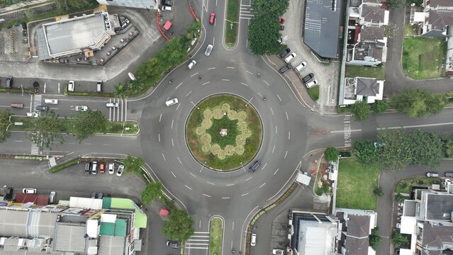 Aerial view of the roundabout at Kota Wisata Cibubur with surrounding residential streets, lush greenery, and vehicles in Kecamatan Gunung Putri, Jawa Barat, Indonesia.