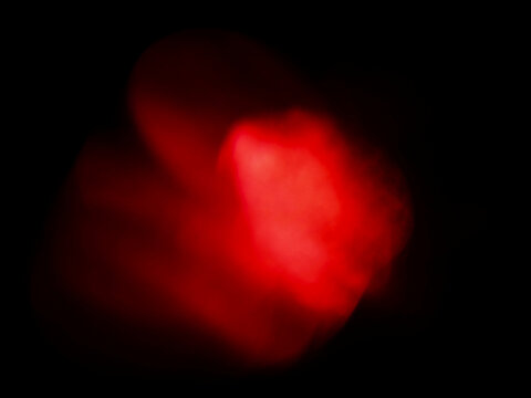 Abstract red light bokeh effect on dark background. Red glowing shapes blend softly. Suitable for creative design or atmospheric backgrounds. No identifiable species present. Light leaks for design.