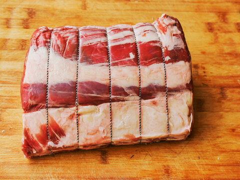 Huge carvery rib roast on the bone is on a wooden cutting board. Butcher craft and skill product. Top quality beef meat with high value and price tag due to premium cut and complicated production.