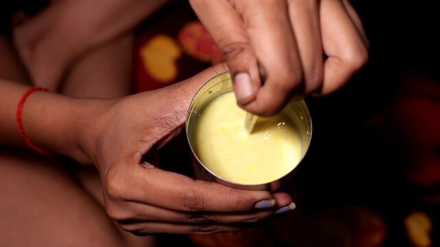 young women mixing turmeric milk by her hand with the selected focus area 