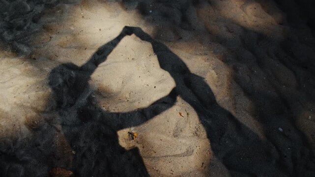 Romantic heart shape shadow of a couple on the sand