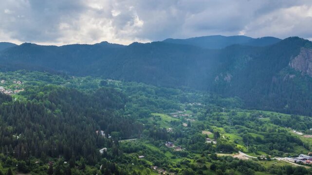 View from rock to town of Smolyan with meadows for cattle walking and houses between mountain range of Rhodope Mountains