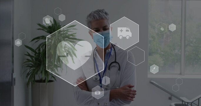 On start senior physician standing arms crossed, hex overlays pulsing heart highlighting vitals