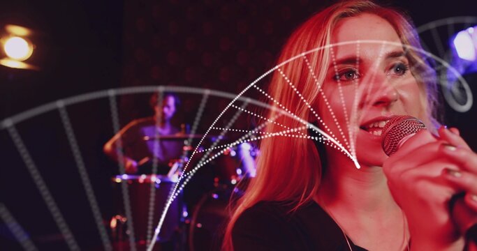 Camera pulling back revealing singer gripping mic performing song as dotted arcs sweeping over her