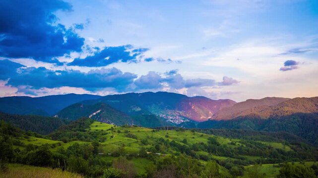 Multicolored sky with clouds and sunset light over the Rhodope Mountains with a intermountain village