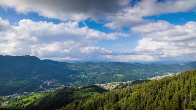 View from rock to town of Smolyan with meadows for cattle walking and houses between mountain range of Rhodope Mountains